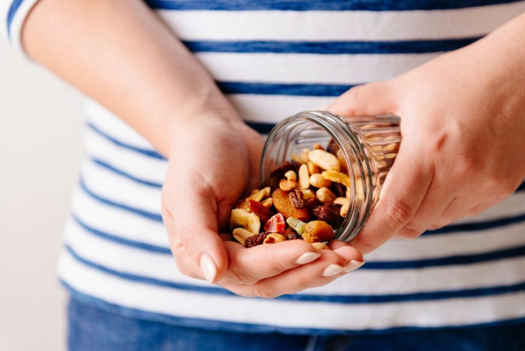 A woman pours a nut assortment into her hand