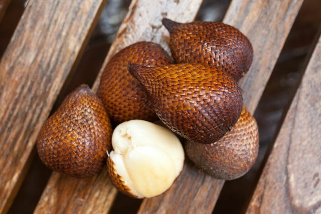 Sliced snake fruit with scaled brown skin and white flesh