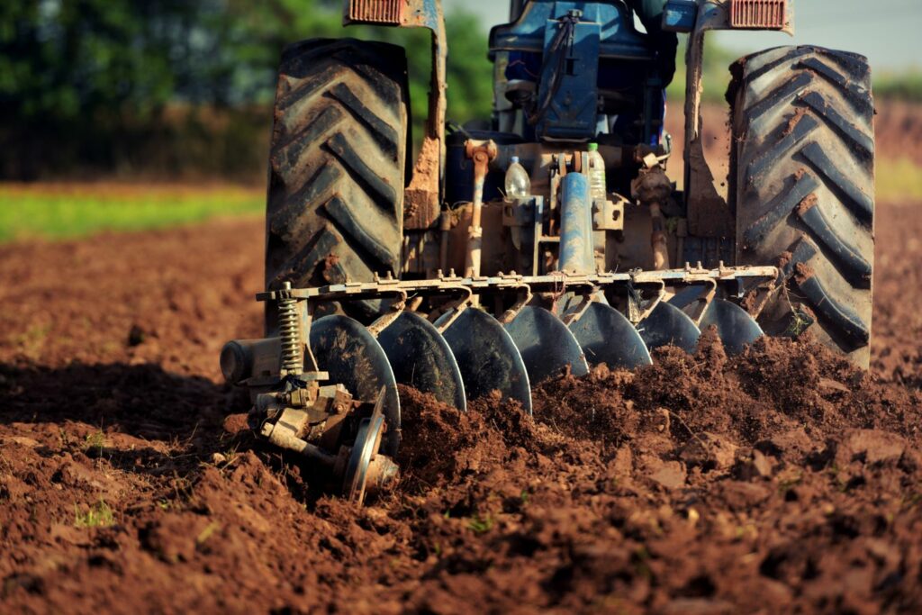 Plough tractor turning soil