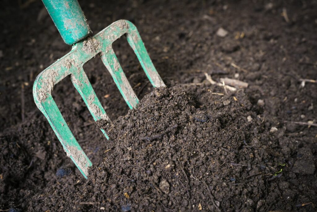 Using a gardenfork to dig up compost