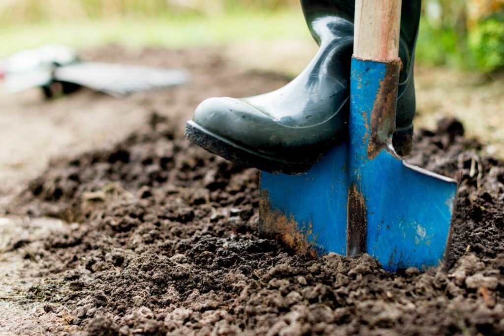 Person digging into ground to create hotbed