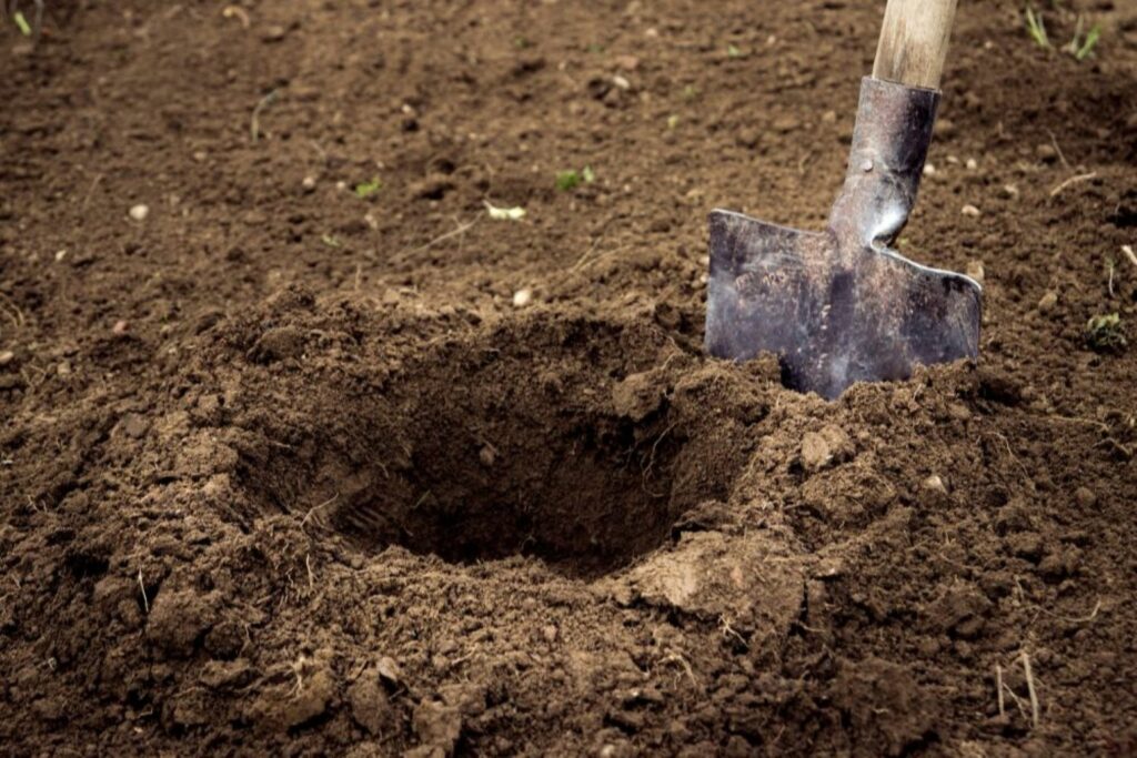 Shovel digging a hole in the ground