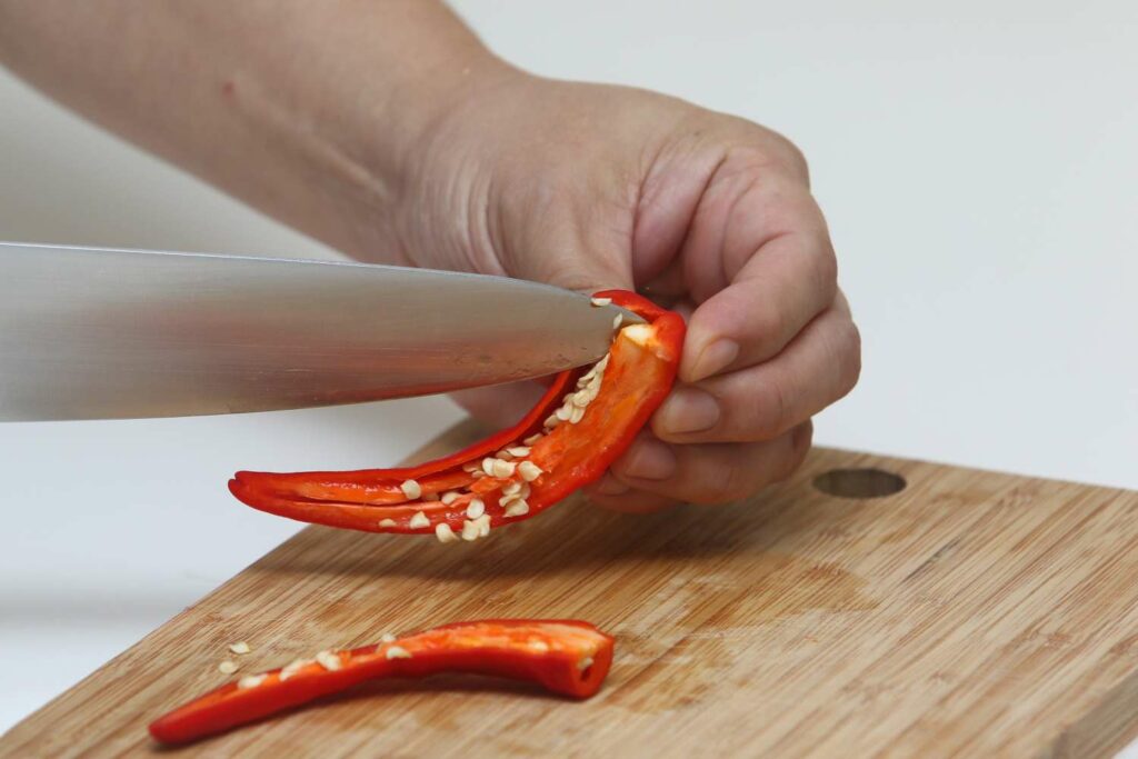 Cutting open chilli pods with a knife
