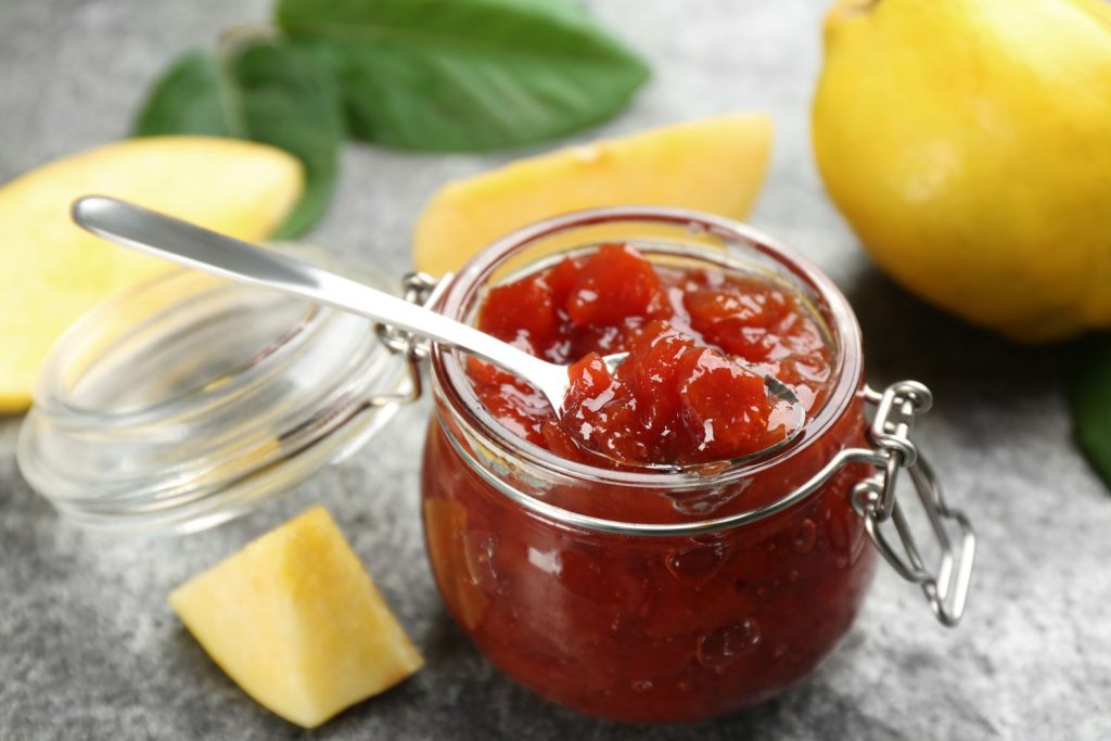 A jar of quince jam with quince fruits